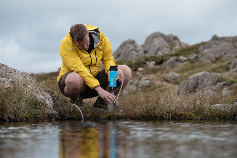 Cargue la imagen en el visor de la galería, A man purifying lake water using a LifeSaver Liberty bottle