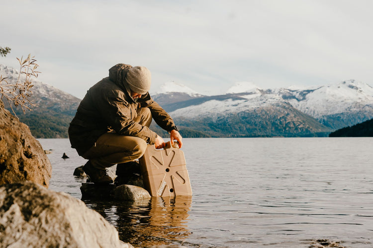 A tan LifeSaver Jerrycan being filled from a lake in Chile