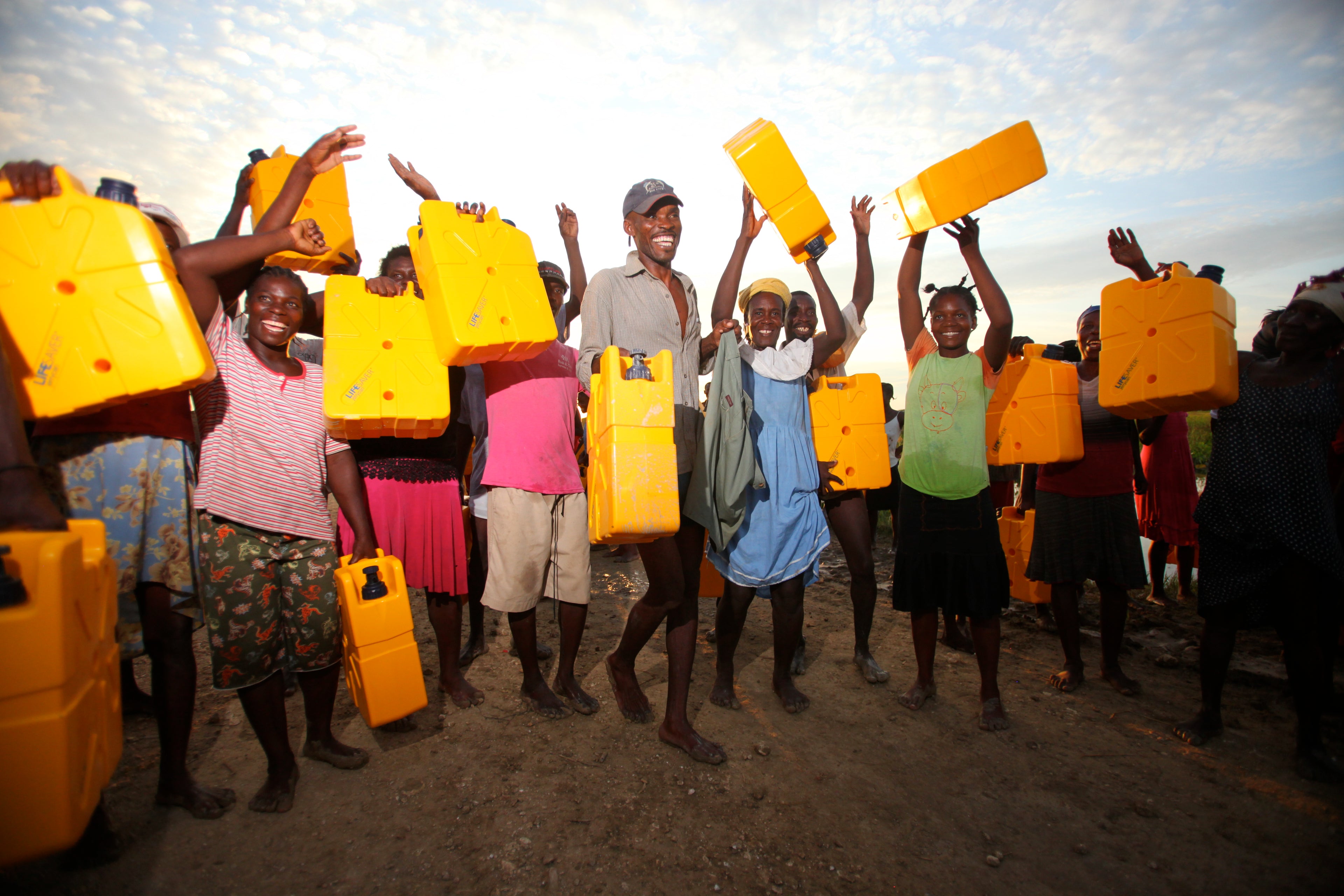 Happy villagers in Haiti with their yellow LifeSaver Jerrycans