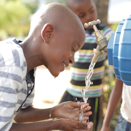 Purified drinking water flowing from a LifeSaver C1 into a child's hands.