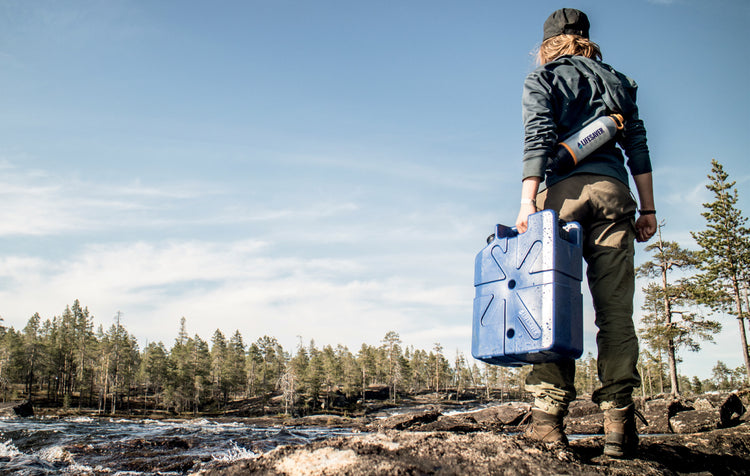 Woman by a river with a Life Saver Bottle and a LifeSaver Jerrycan