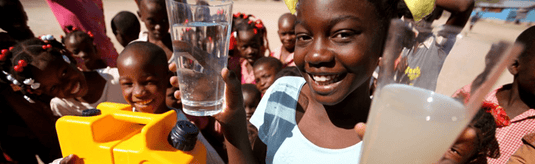 Happy African children drinking water purified by a LifeSaver Jerrycan