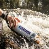 LifeSaver water purifier bottle being used to filter moving river water