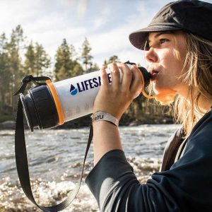 Girl drinking from the LifeSaver 4000UF Bottle by a river in Sweden